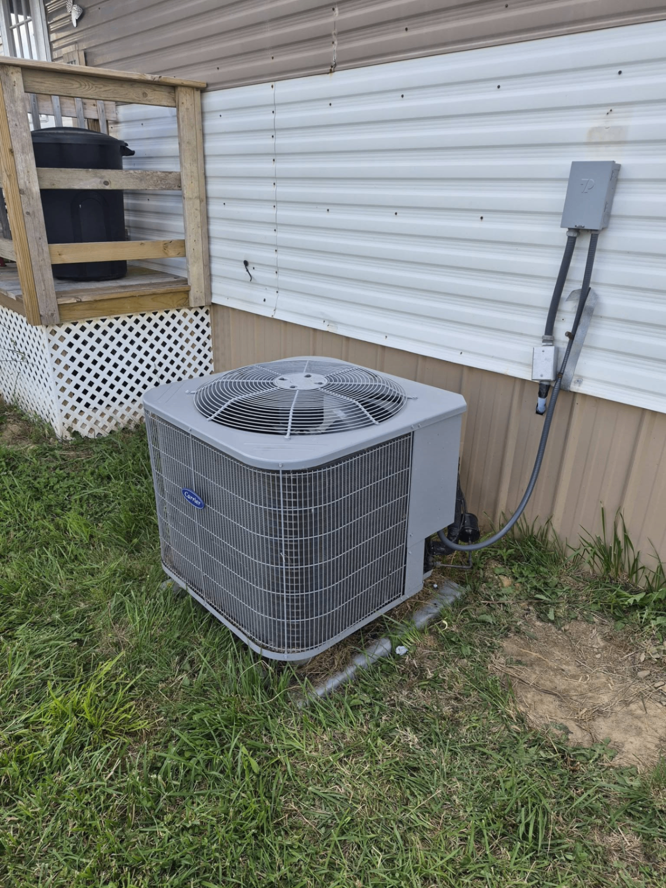 Carrier outdoor AC condenser installed beside a home